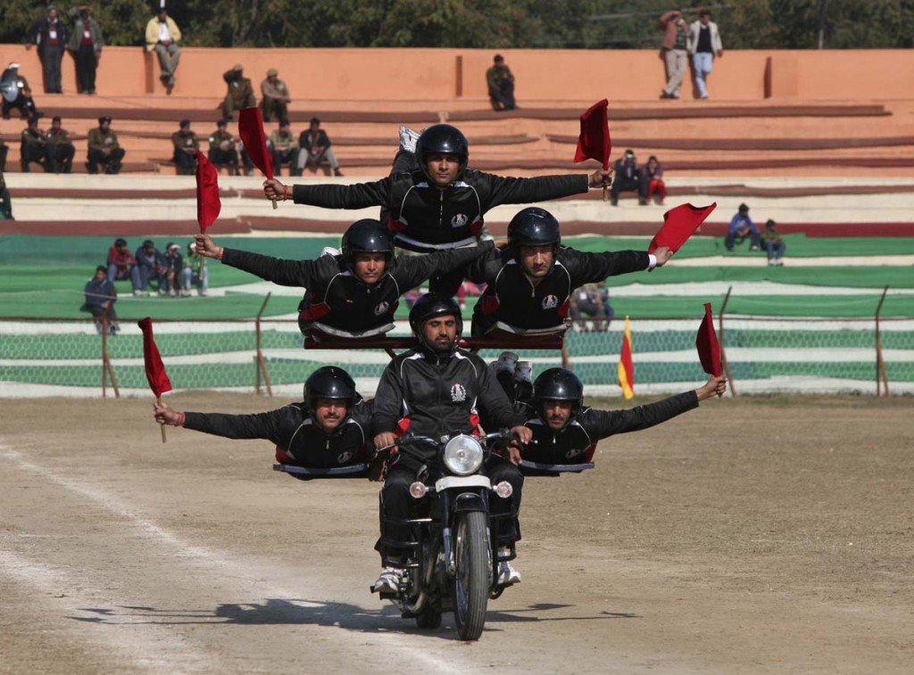 Indian policemen perform a stunt on a motorcycle during the Republic Day parade in Jammu